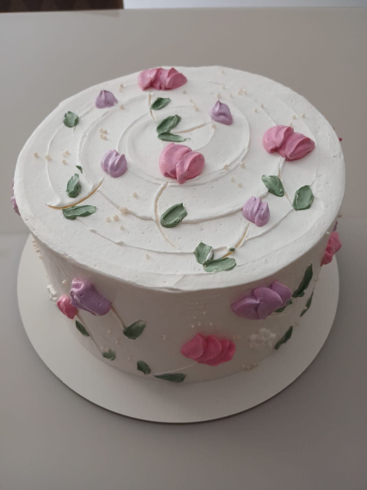 Bolo decorado branco com flores lilás e rosa de chantininho