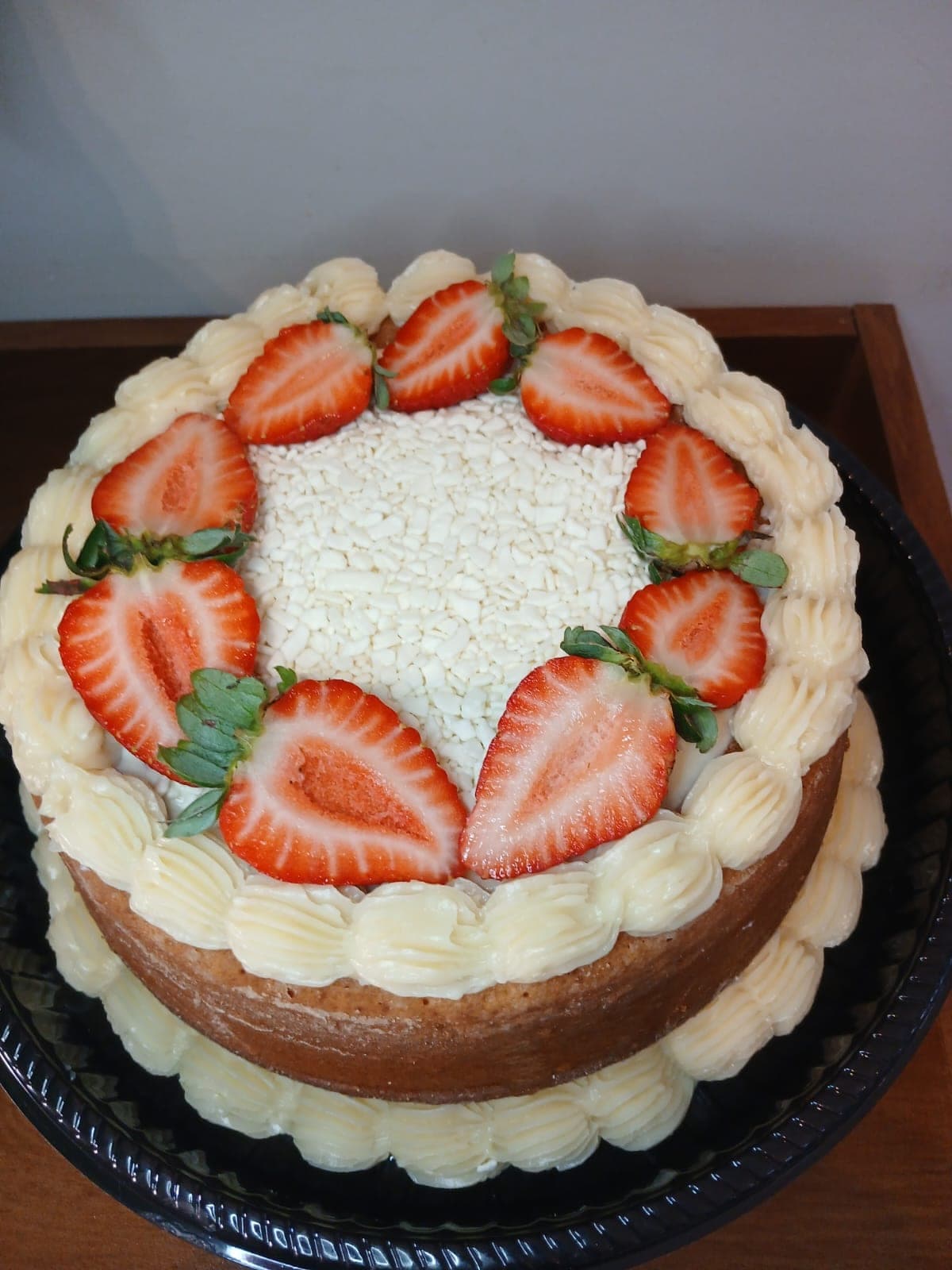 Naked cake com creme nas bordas e morangos por cima